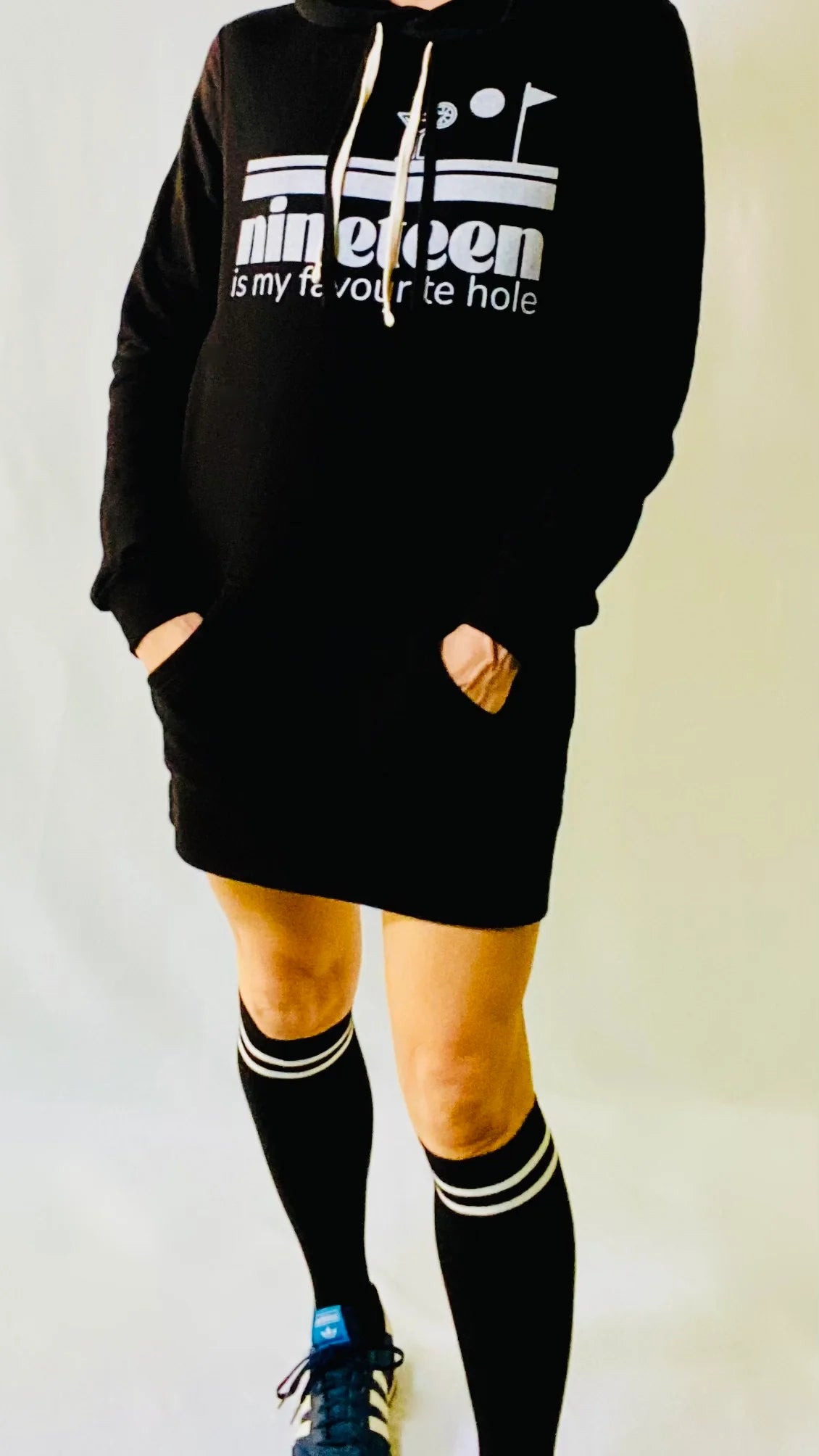 A woman wearing a Nineteenth hole sweatshirt dress by Golf Garter