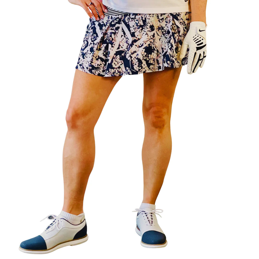 A woman in a patterned skirt wearing the golf garter accessory hidden underneath her skirt.